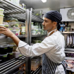 Chef trabalhando em um restaurante e procurando alguns ingredientes na despensa