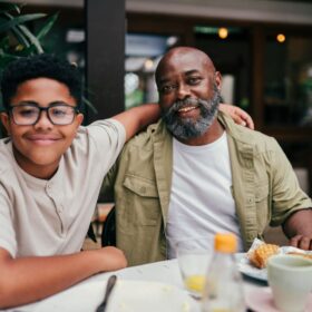 Retratos de pai e filho tendo uma refeição em um restaurante durante o dia