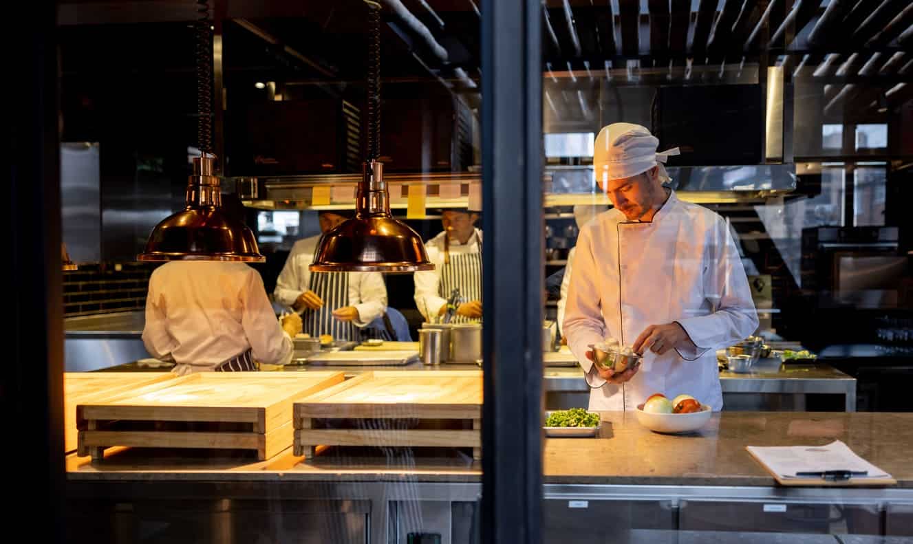 Chef preparando comida no restaurante com sua equipe de cozinheiros
