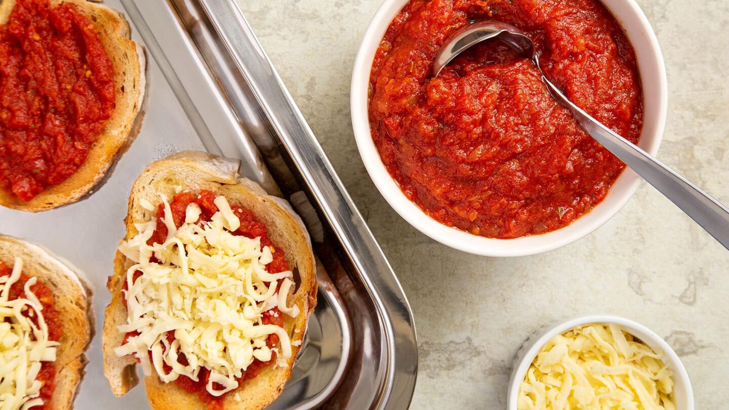 Bruschetta em uma travessa de vidro com um molho ao lado