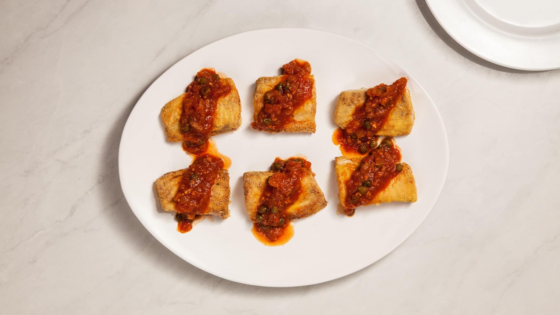 Filé de peixe com molho de tomate e alcaparra