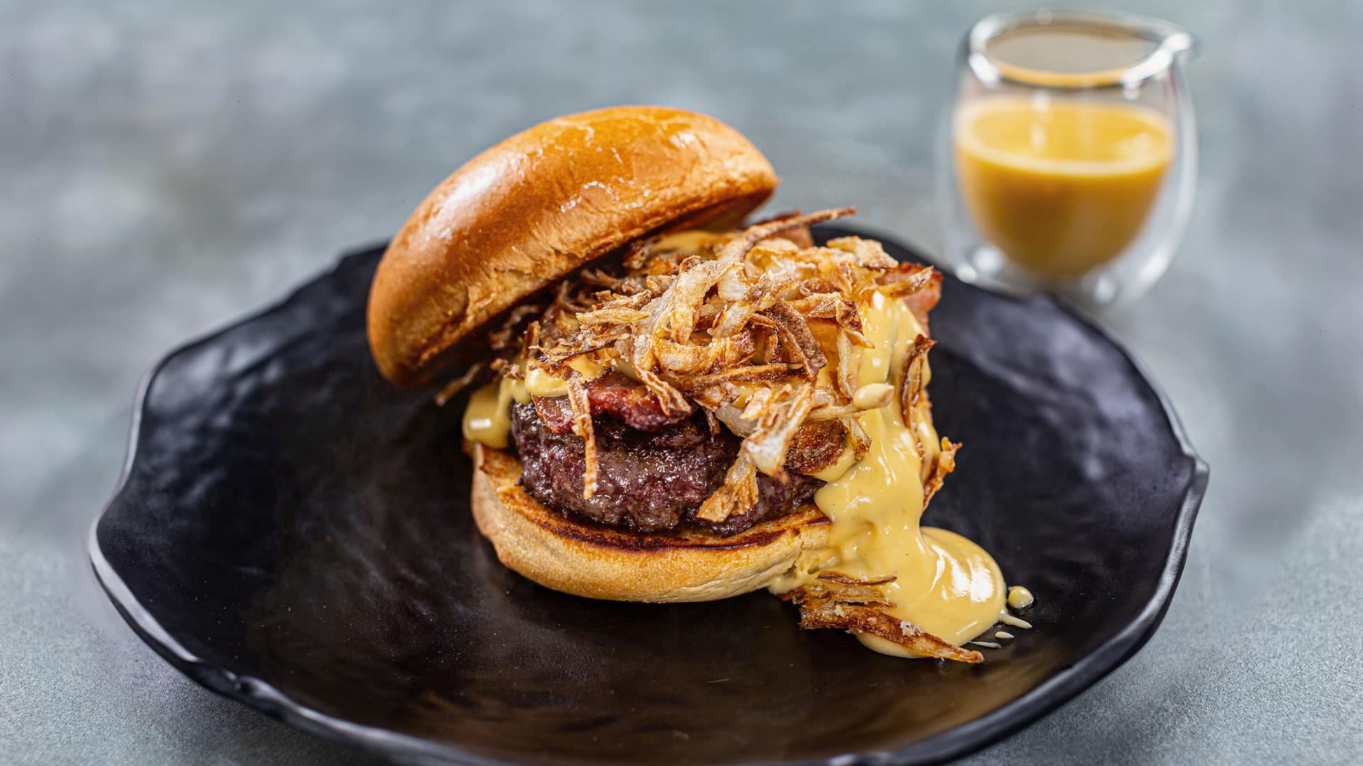 Hambúrguer, bacon, creme de queijo, picles e cebola caramelizada